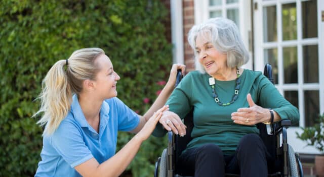 a disability support worker caring for an elderly woman in a wheelchair