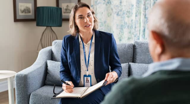 women speaking with an elderly man