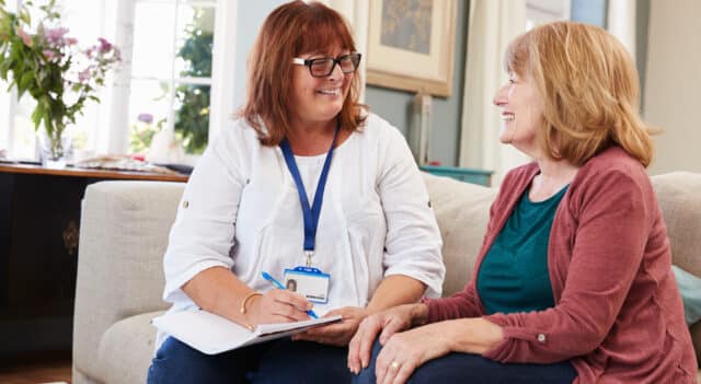 two ladies sitting together on a couch conducting a support worker health check