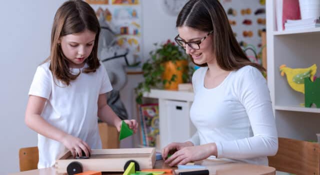 a woman teacher with a young girl educating her in the classroom