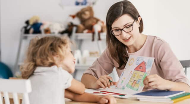 a lady in a classroom teaching a young girl